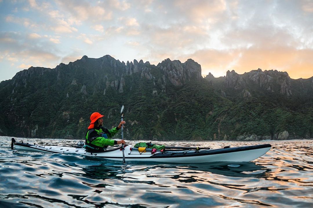 Scenic photo of a sea kayak infront of mountains